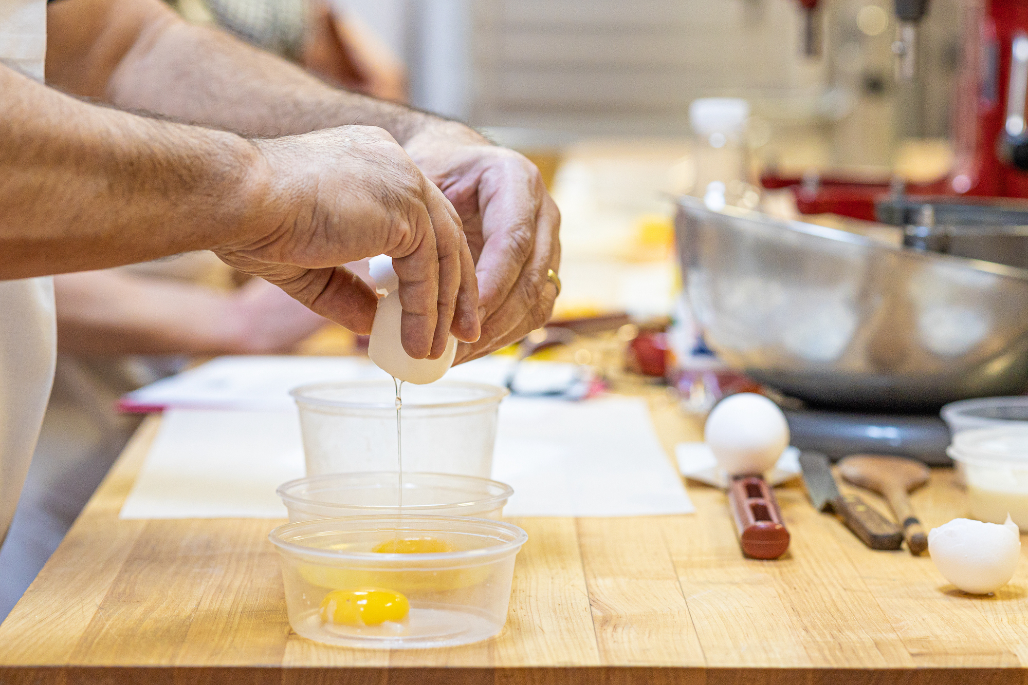 Photo of people at an in person class breaking eggs