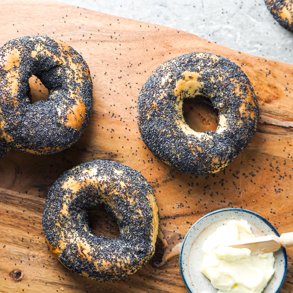 Poppy Seed Bagels and Butter on wooden cutting board