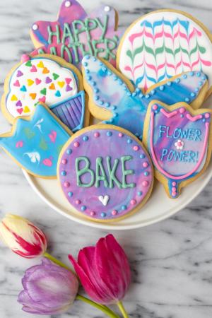 A plate of cut-out sugar cookies decorated in a spring theme