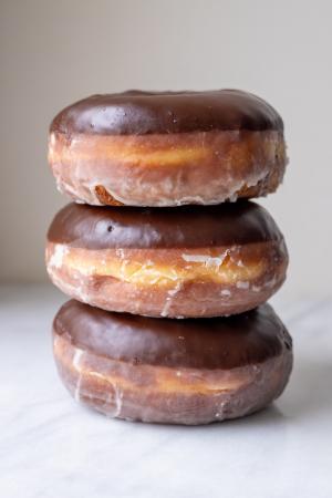 a stack of 3 chocolate glazed doughnuts