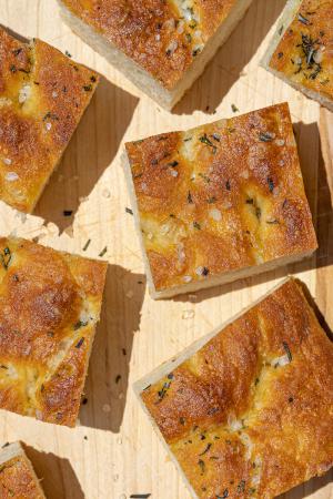 slices of rosemary and sea salt focaccia on a wooden cutting board