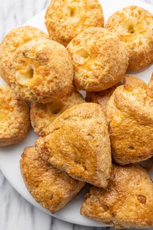 A platter of ginger scones and cheddar herb scones on a marble surface.