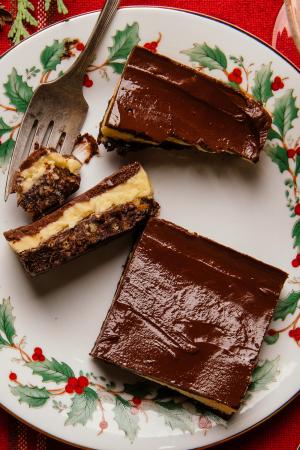 nanaimo bars on a holiday themed dessert plate with a fork