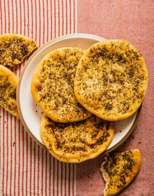 za'atar flatbread on a plate; torn pieces of flatbread lie next to the plate